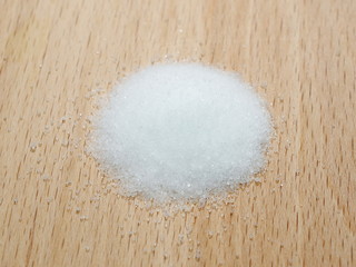 macro pile salt isolated on wooden plate background