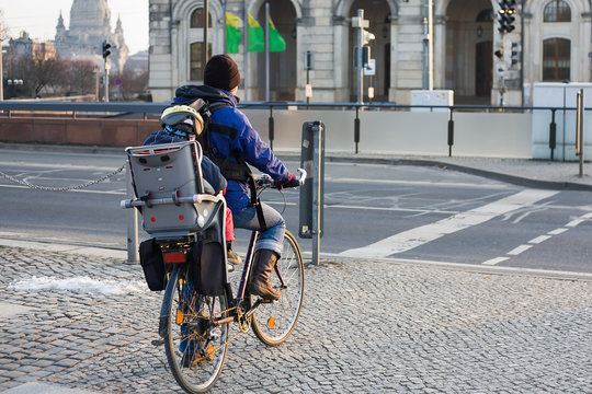 Girl with a child on a bicycle at the crosswalk in Dresden

