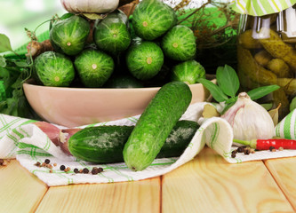 Pickled and fresh cucumbers on kitchen table