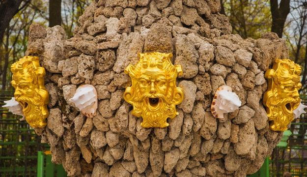 Detail of an old fountain with shells and golden mask