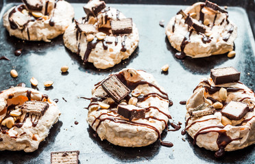 meringue with chocolate and caramel topping, nuts and souffle, d