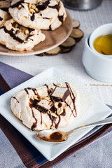 vanilla meringue with chocolate, caramel and nuts, sweet cake, a