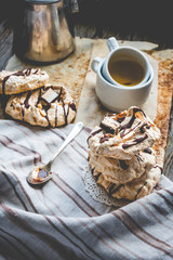meringue cake with chocolate, caramel and nuts, dessert, rustic