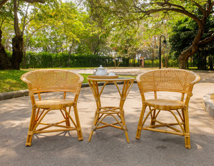 Fototapeta na wymiar Wooden Rattan Chairs with Set of Tea on Table for Afternoon Tea