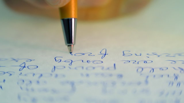 Pen writes a letter on paper