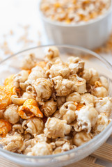 A bowl of popcorn on a wooden table, caramel popcorn