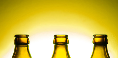 offene Bierflaschen vor gelbem Hintergrund