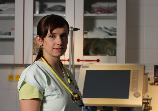Portrait female nurse in ICU in green uniform with ventilator ma