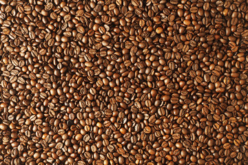 Top view of roasted coffee beans spread on stone table