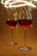 wine glasses on glitter lit by sparkling sticks