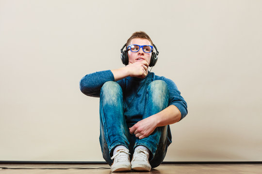 Young Man With Headphones Sitting On Floor