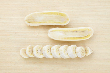 yellow banana in bunch and slice on wood