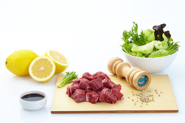 Fresh steak with spices on wooden background