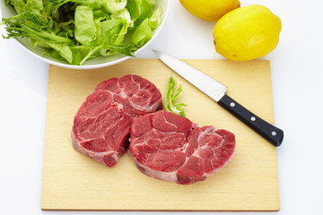 Fresh steak with spices on wooden background