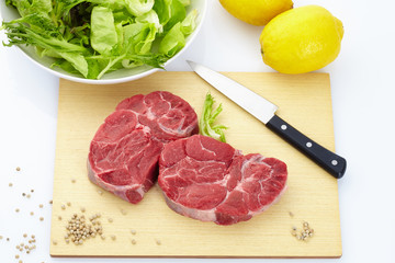 Fresh steak with spices on wooden background