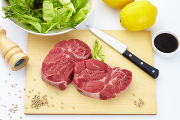 Fresh steak with spices on wooden background
