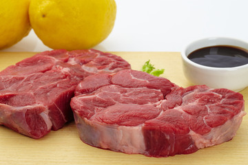 Fresh steak with spices on wooden background