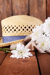 Obraz na płótnie Canvas Hat with flowers on wooden background