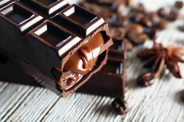 Stuffed chocolate with coffee beans on wooden table, closeup