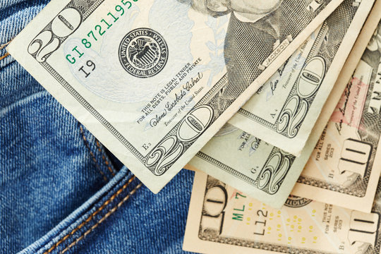 Dollars on jeans background