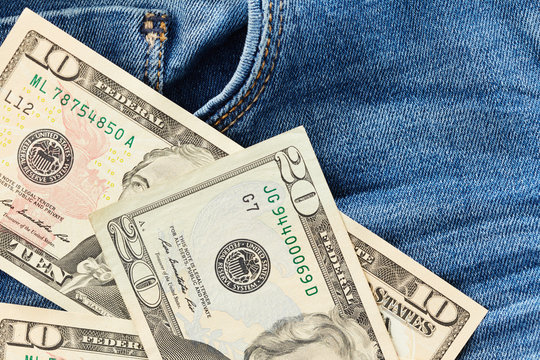 Dollars on jeans background