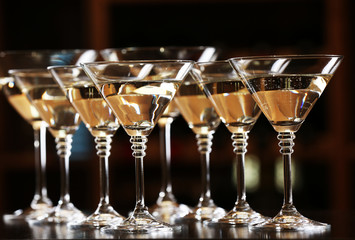 Glasses of cocktails on bar background