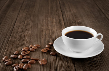 Cup of hot coffee on a wooden table. Coffee beans.