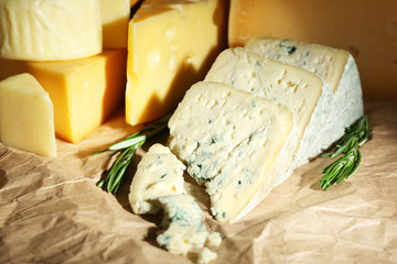 Various types of cheese with rosemary on table close up