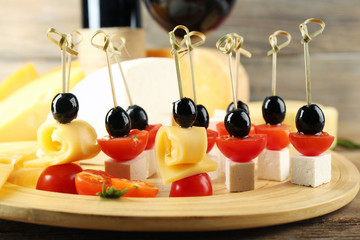Cheese canapes with wine on table close up