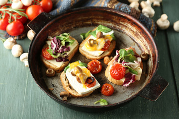Tasty sandwiches on old pan, on wooden table