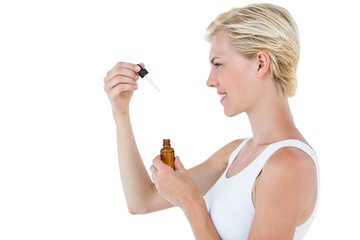 Smiling blonde woman holding bottle of medicine 