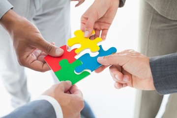 Business colleagues holding piece of puzzle