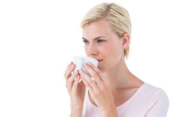 Attractive blonde woman drinking hot beverage