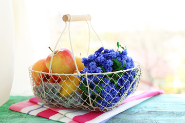 Beautiful bouquet of muscari - hyacinth with fruits in metal basket on windowsill