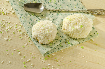 Twoo cookies with coconut flakes on cotton cloth. Near spoon.
