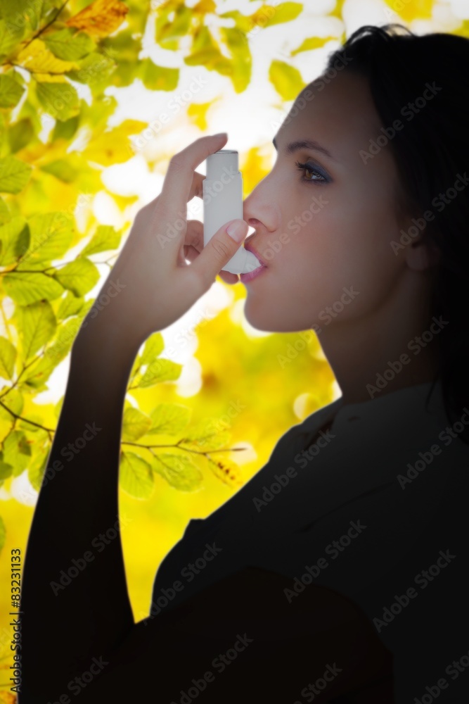 Poster Composite image of asthmatic brunette using her inhaler 