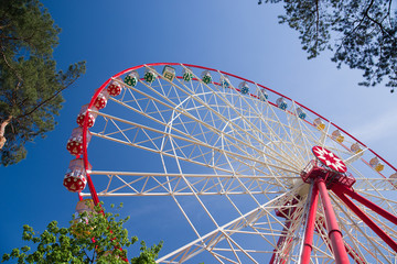 Atraktsion Ferris wheel against the blue sky