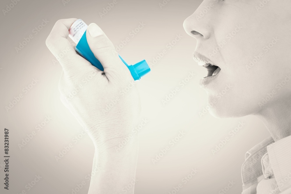 Poster Composite image of close up of a woman using an asthma inhaler