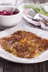 Potato fritters, beet salad, green onions on a wooden surface
