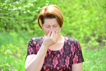 Woman with rhinitis in  summer park