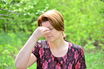 Woman with rhinitis in  summer park