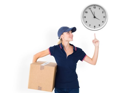 Happy delivery woman holding cardboard box and pointing up