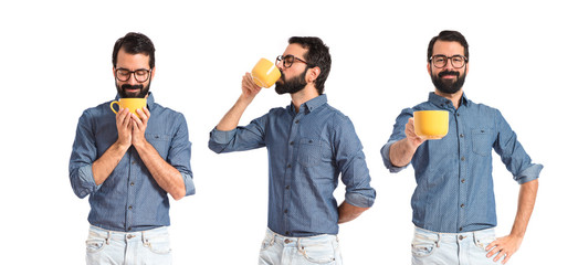Young hipster man drinking coffee over white background