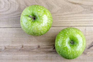 Two green apple over wood.