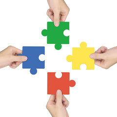 cooperation concept: hands holding jigsaw pieces