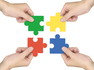 cooperation concept: hands holding jigsaw pieces