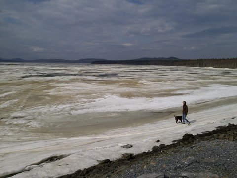 Female torist with her dog on a frozen lake