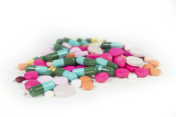 Stack of different pills on white background