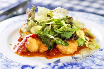 Salad with fried fish fillet, red pepper and salad mix