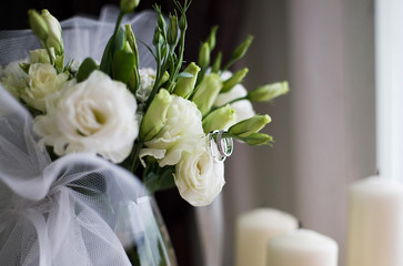 Wedding rings and bouquet of roses